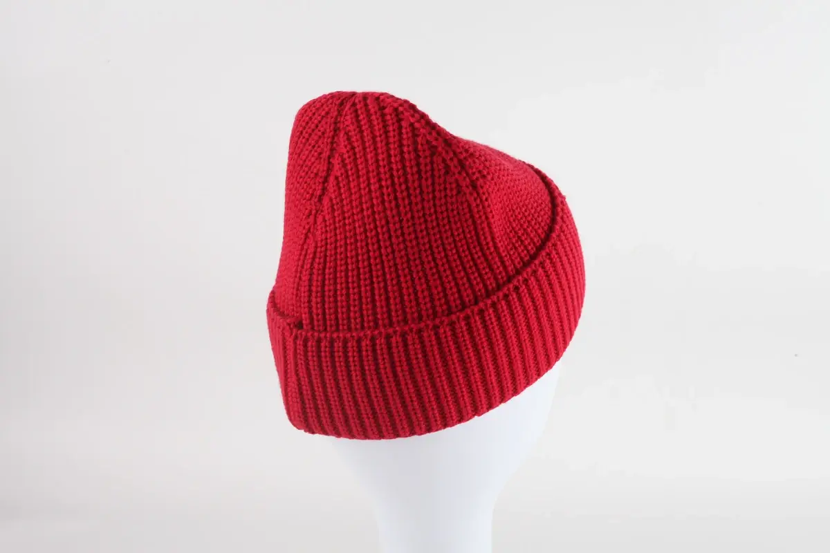 Red rib-knit beanie with a folded cuff on a white display form