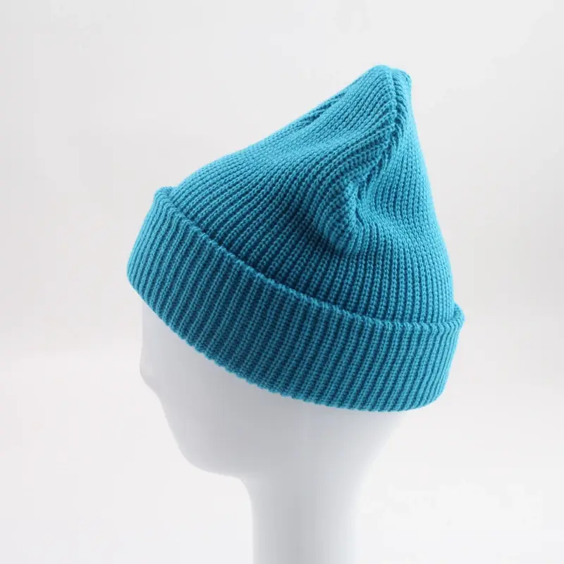 Blue rib-knit beanie shown at an angle with a small front tab