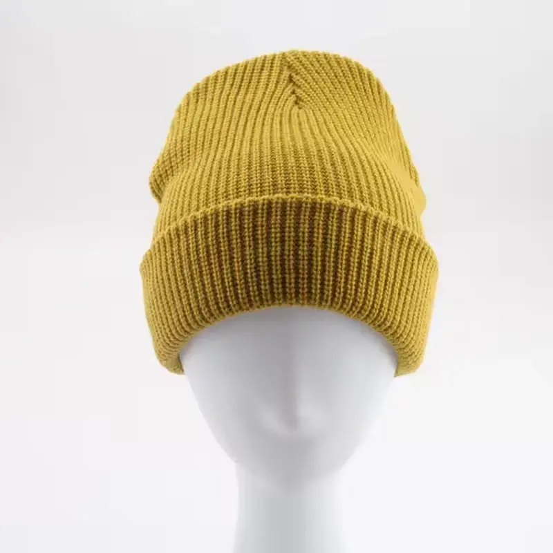 Mustard rib-knit beanie with a folded cuff on a white display form