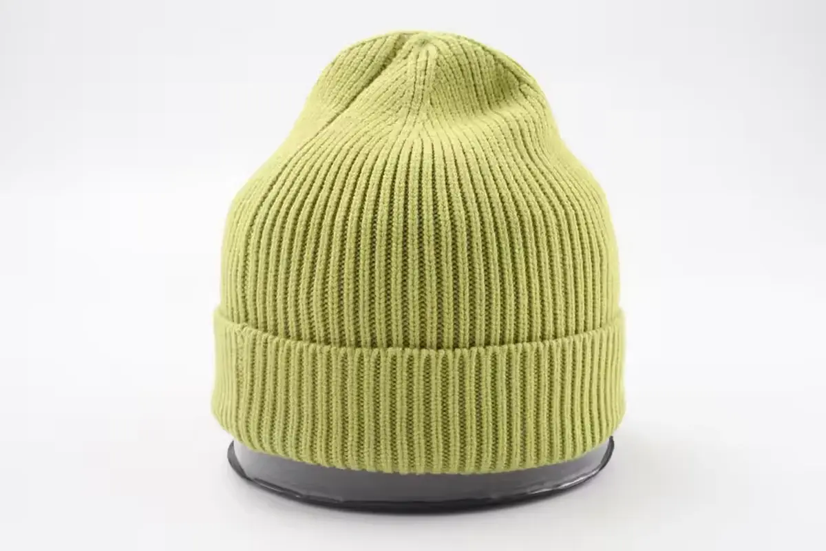 Light green rib-knit beanie with a folded cuff on a white display form