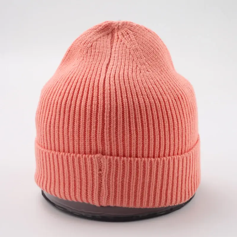 Coral rib-knit beanie with a folded cuff on a display form