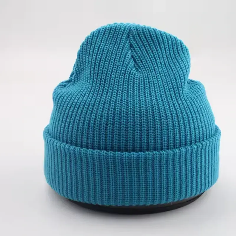 Blue rib-knit beanie with a folded cuff on a white display form