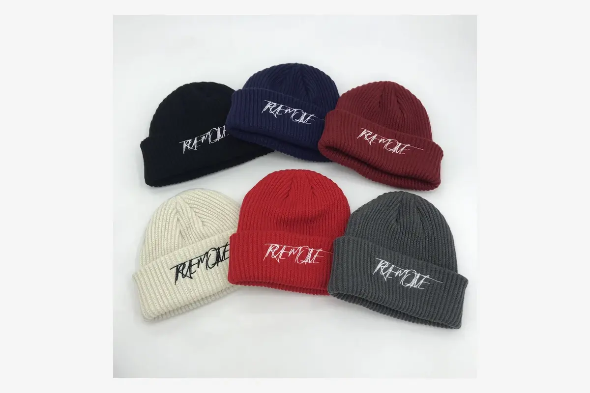 Six cuffed knit beanies with the same embroidered wordmark.