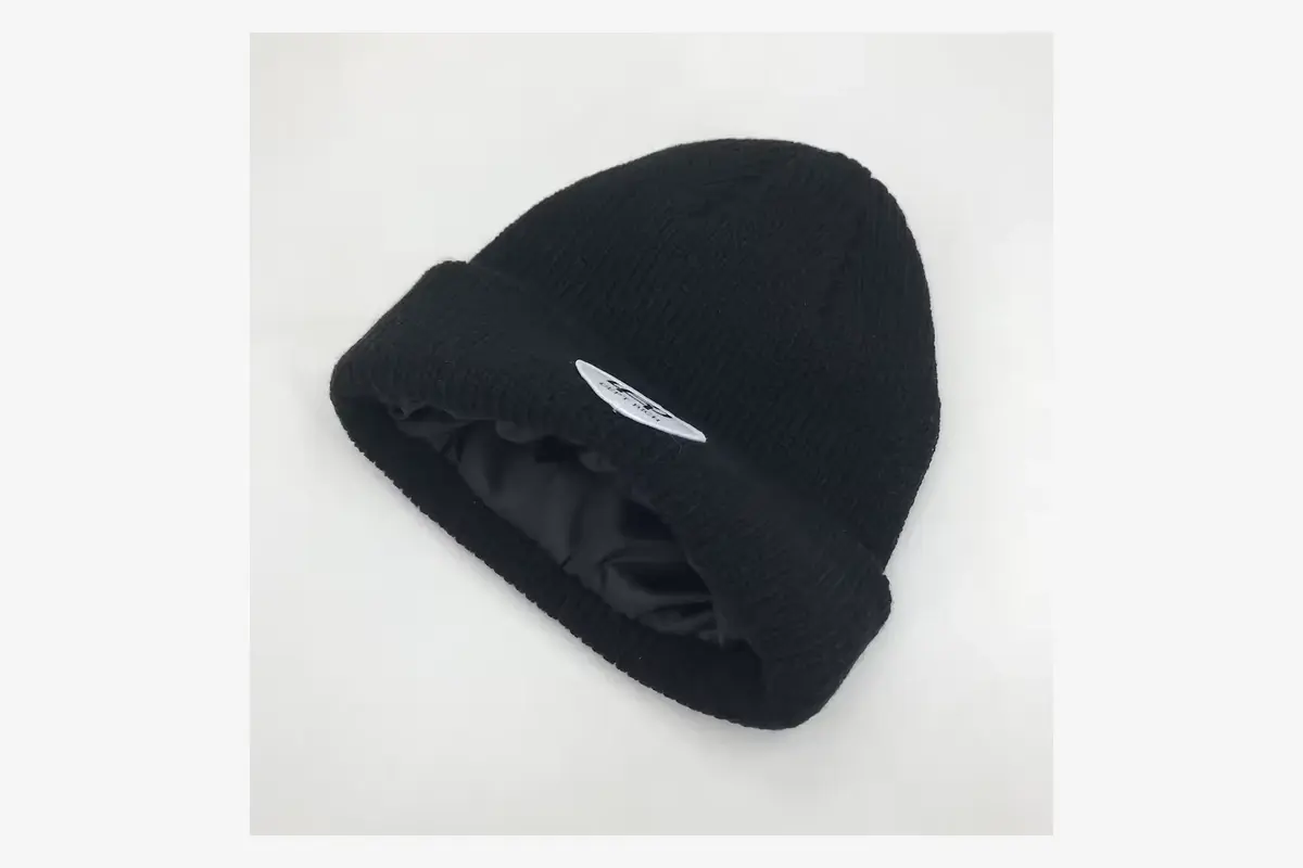 Black knit beanie showing the inner lining and edge seam.