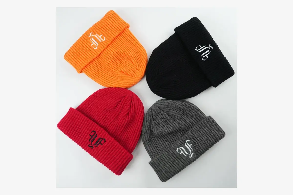 Four embroidered beanies in different colors for appearance comparison.