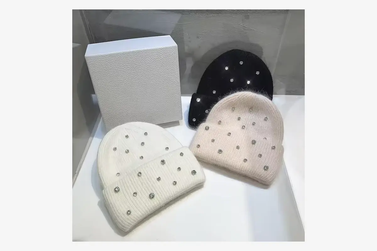 Three finished beanies displayed beside a plain presentation box.