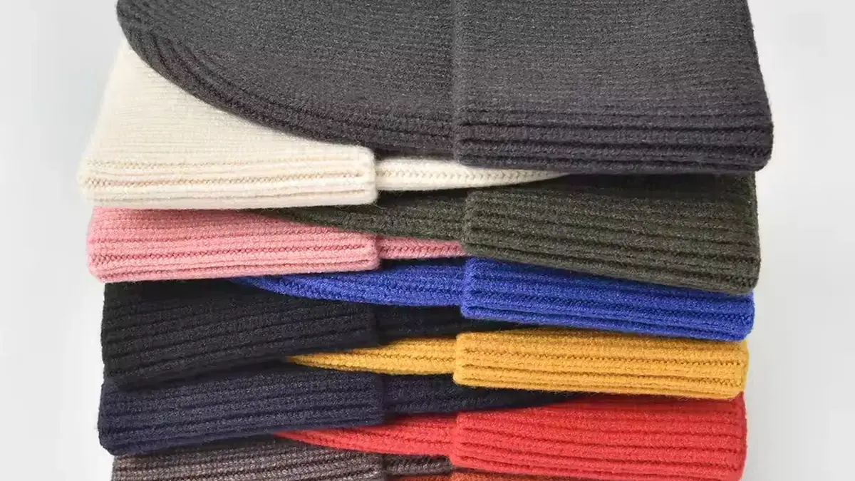 Stack of rib-knit beanies in assorted colors.