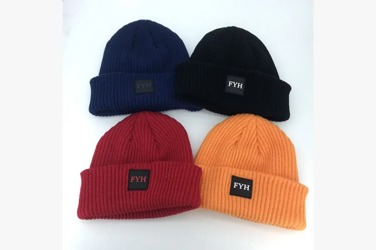 Four ribbed cuffed beanies in different colors with the same front label
