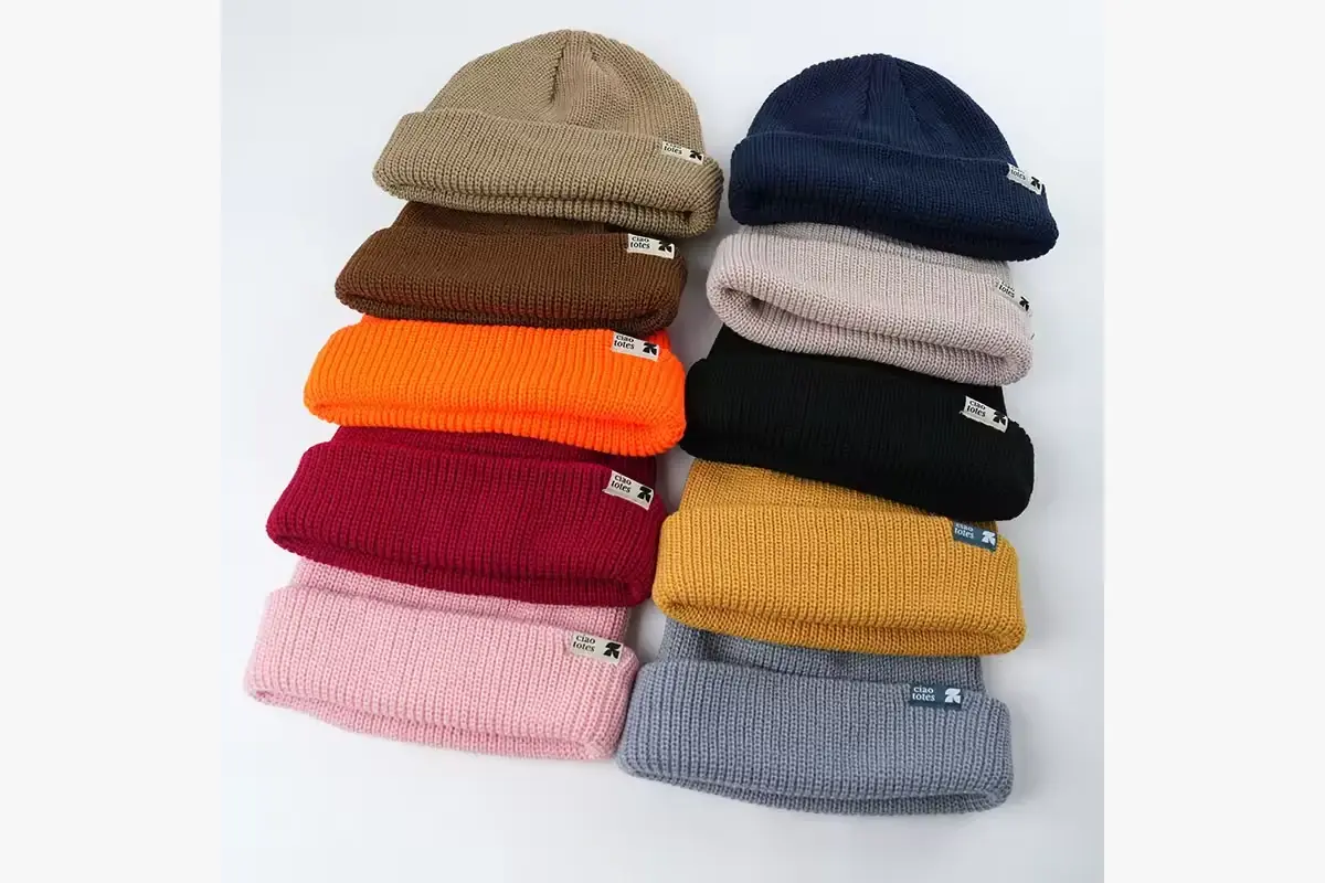 Stacks of finished cuffed beanies in several colors