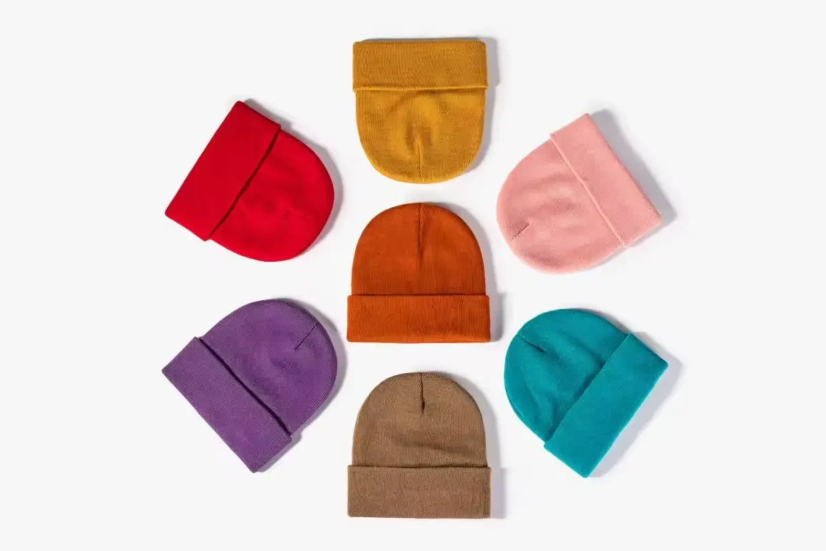Cuffed beanies arranged by color on a light background