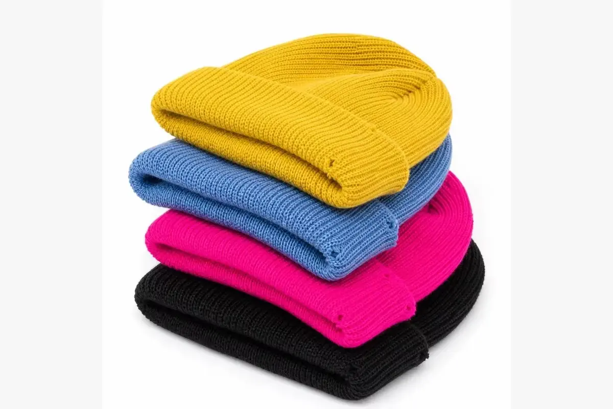 Folded knit beanies in yellow, blue, pink and black showing color and texture