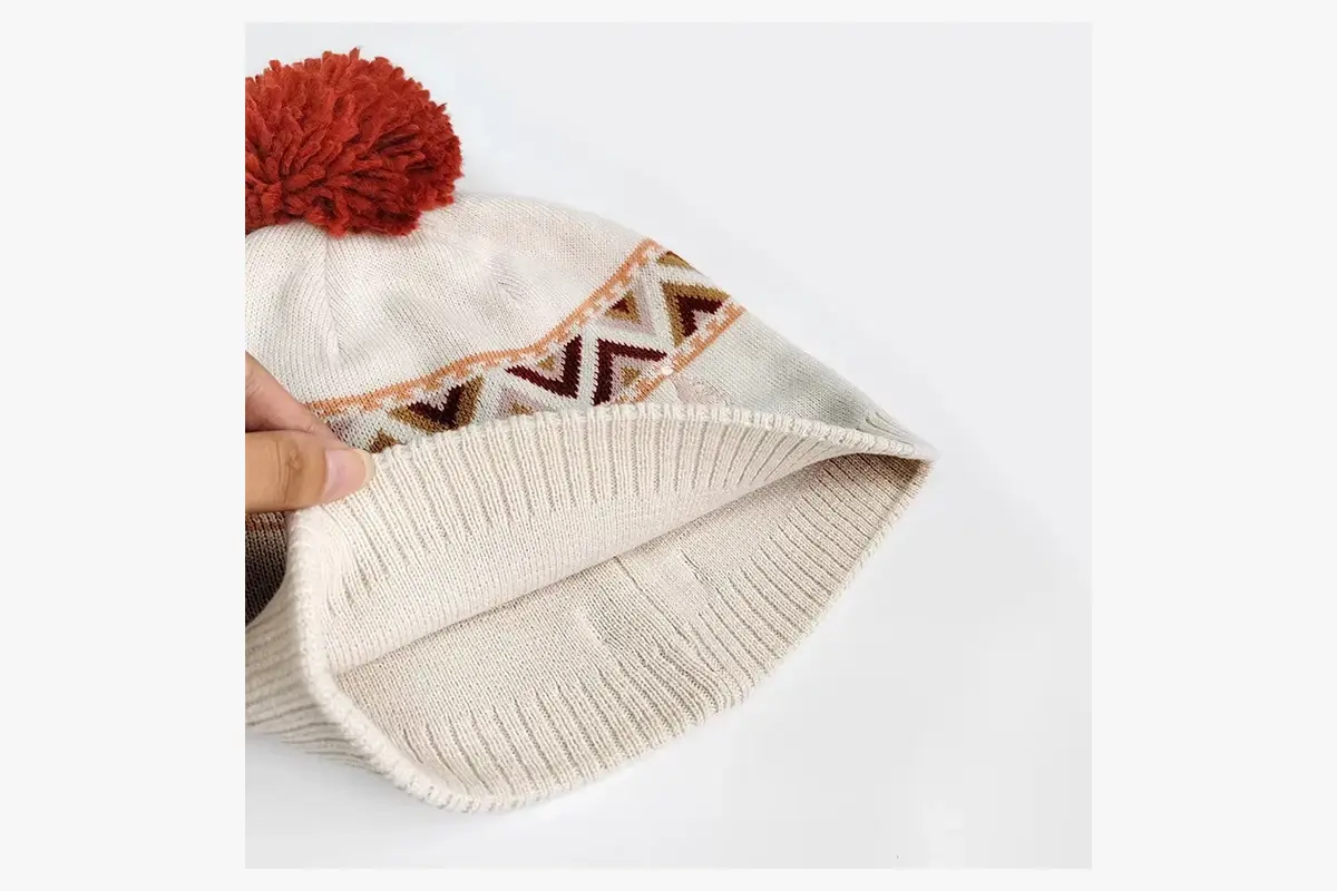 Cream patterned beanie opened to show its plain knitted inner surface