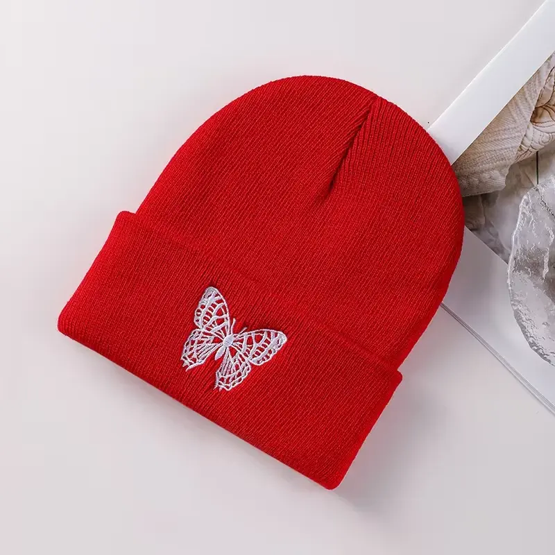 Red knit beanie with a small white embroidered butterfly on the cuff