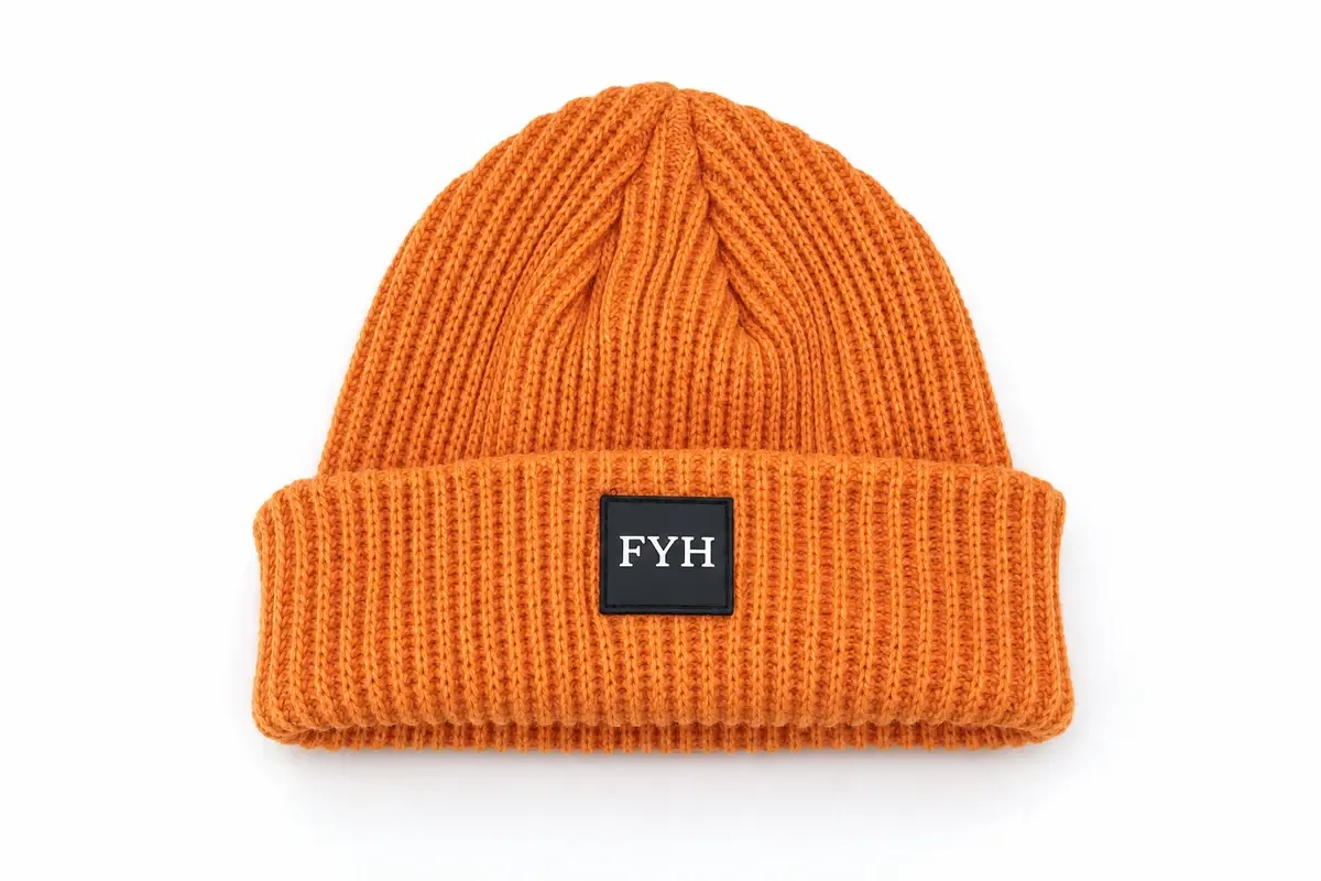 Orange cable-knit cuffed beanie showing its crown, cuff and FJH patch