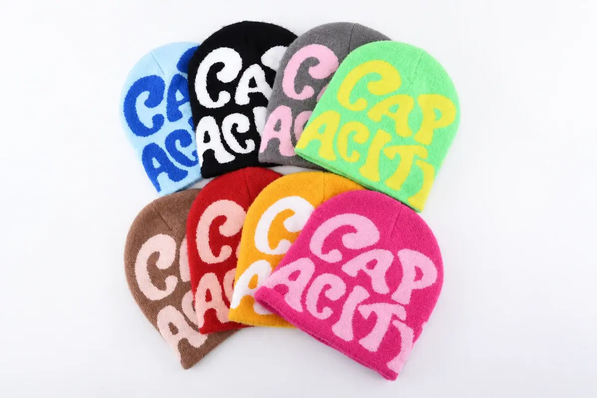 Group of colorful cuffless knit beanies with embroidered graphics