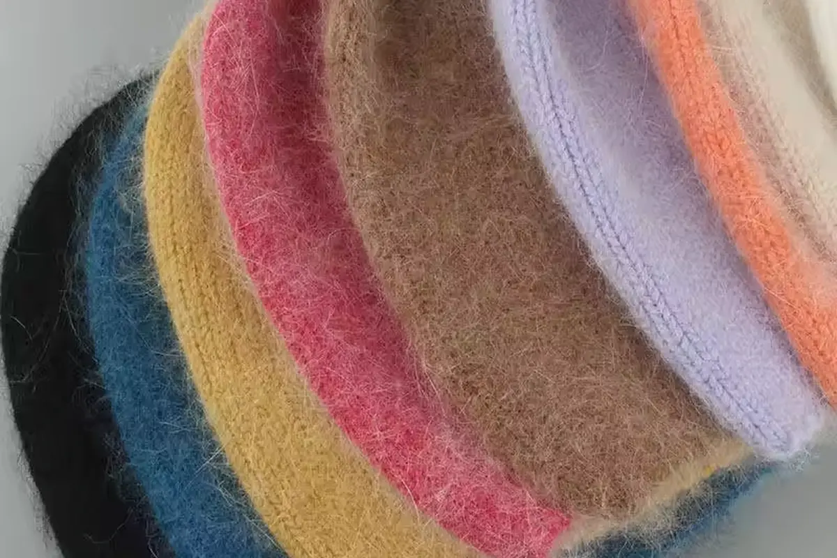 Close view of the finished lower edges of knit beanies in several colors