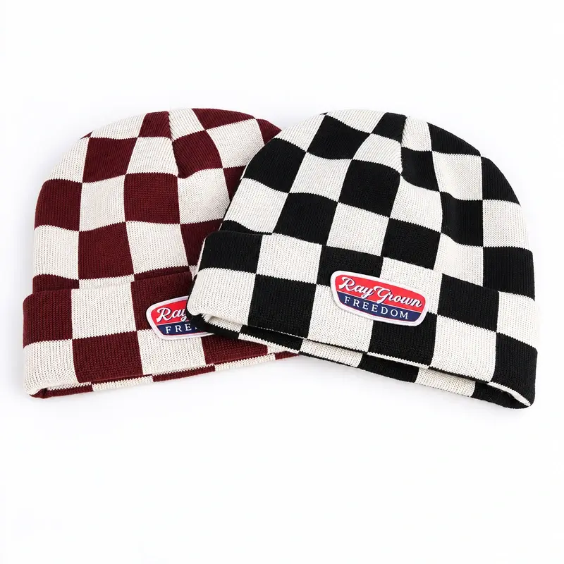 Navy and burgundy short fisherman beanies with sewn woven patches on the folded cuffs