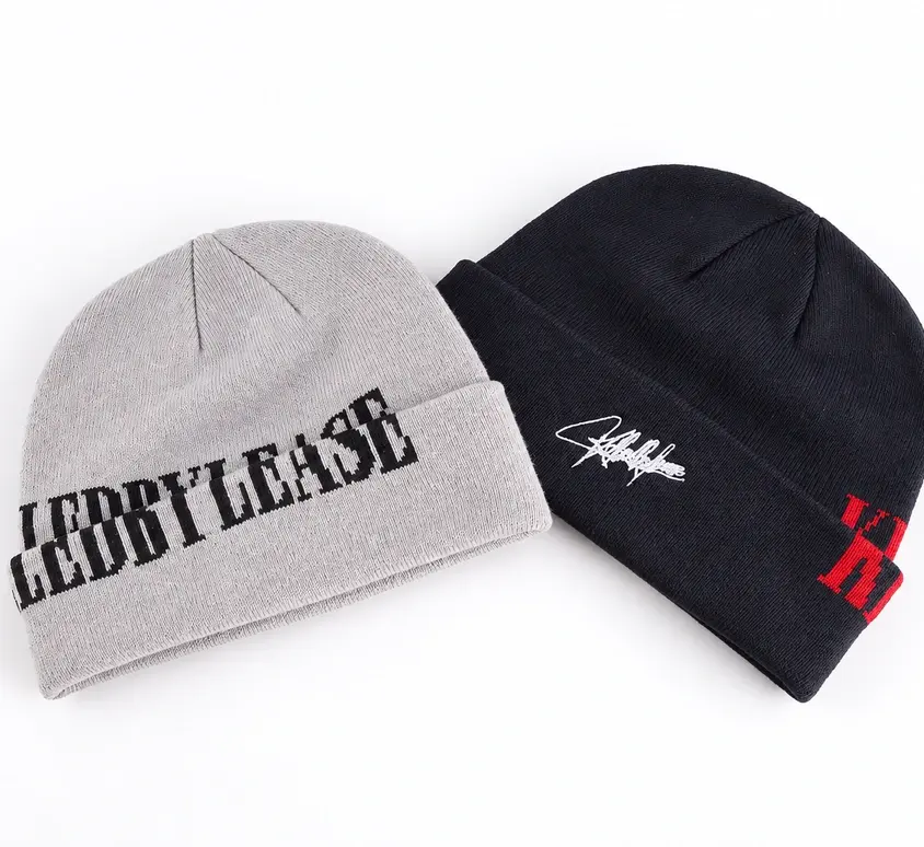 Two short fisherman beanies showing embroidered cuff lettering and small embroidered marks