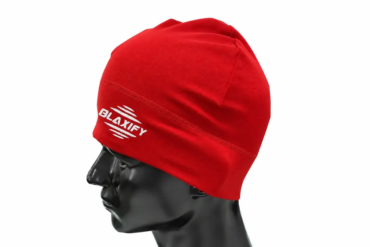 Red tall knit beanie with woven branding on a dark display head