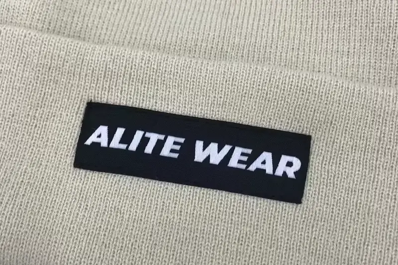 Close view of a dark woven label on light ribbed knit