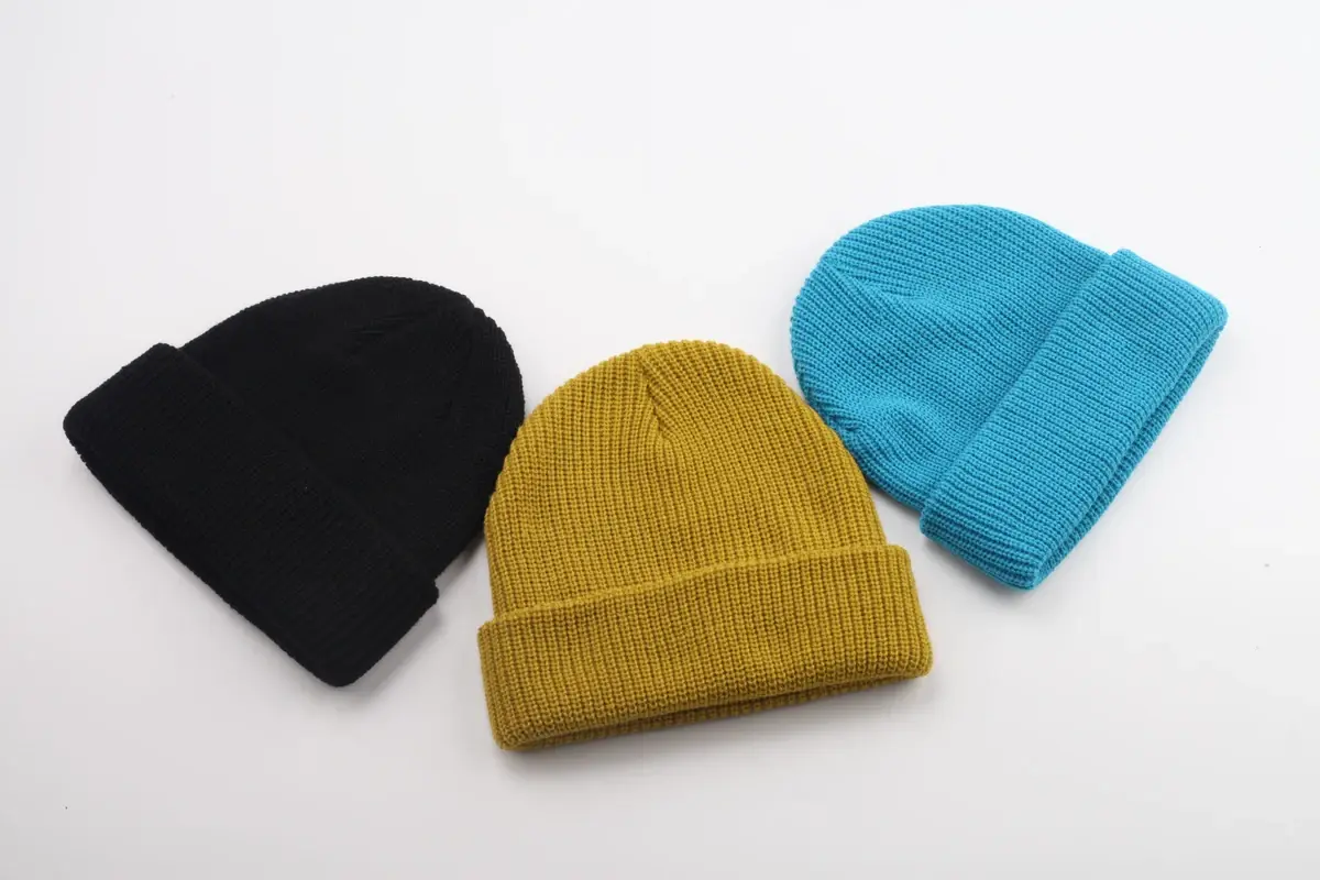 Three knit beanies in black, yellow and blue