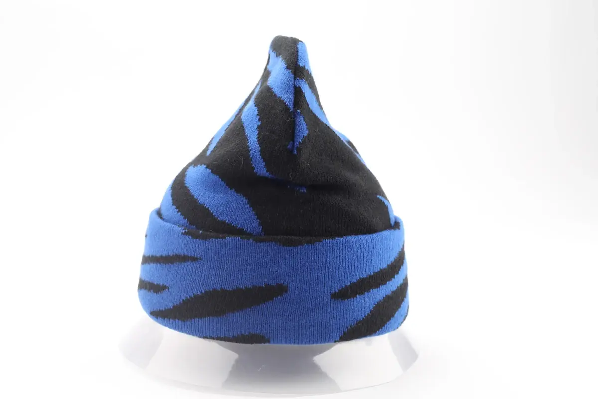 Blue and black striped knit beanie shown from the side