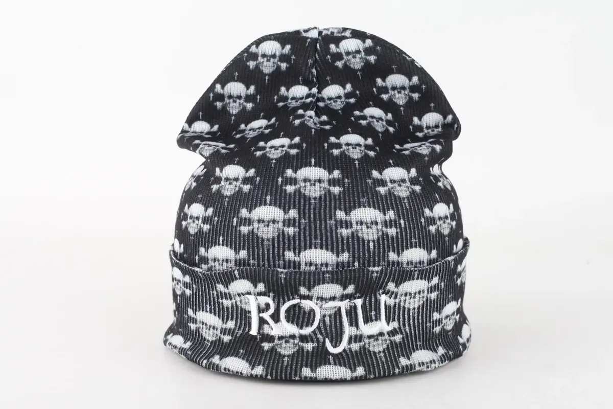 Black beanie with a white skull pattern and knitted cuff lettering