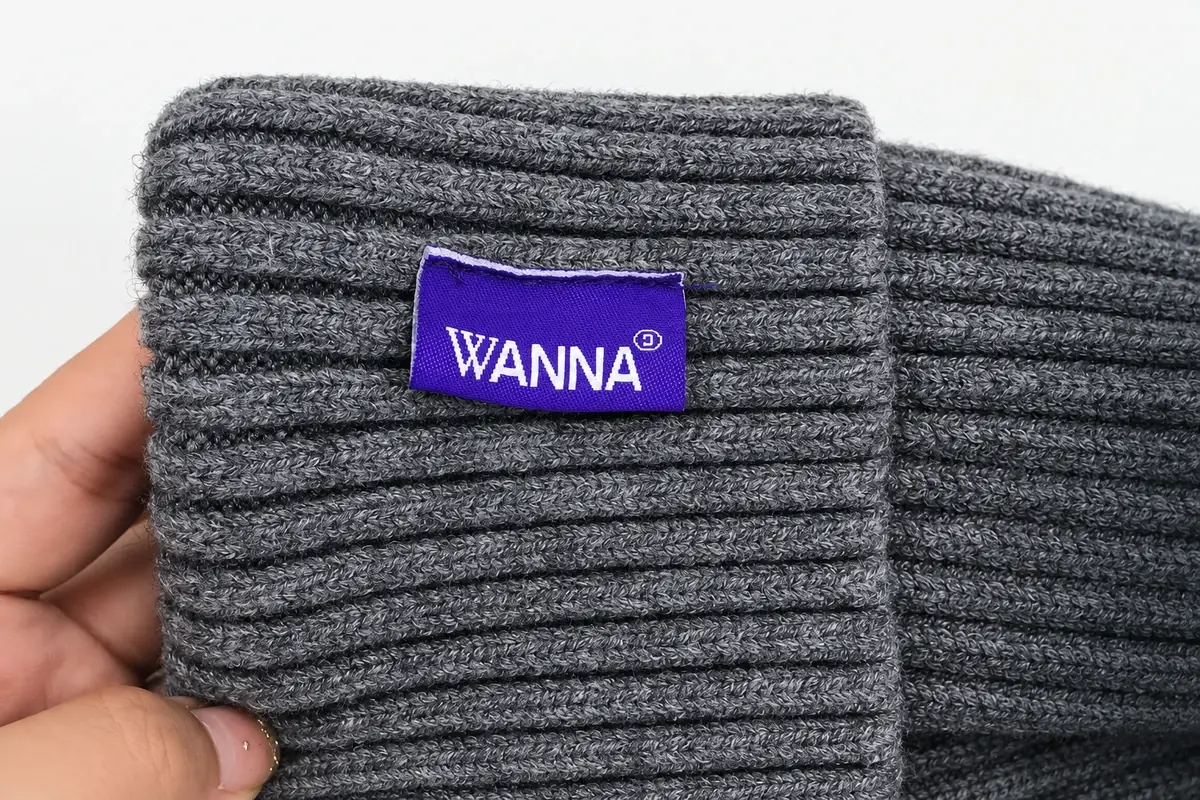 Close-up of dark rib-knit beanie with purple woven brand patch