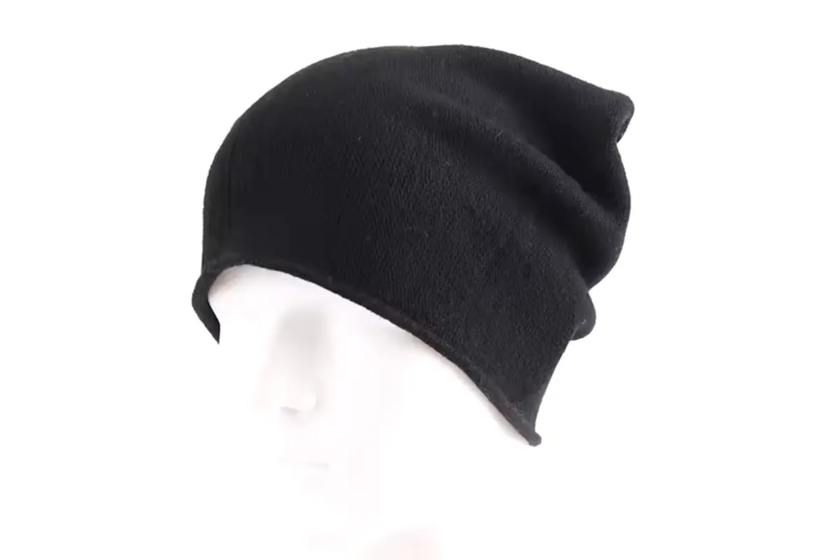Black lightweight knit beanie with a relaxed slouchy crown on a display head