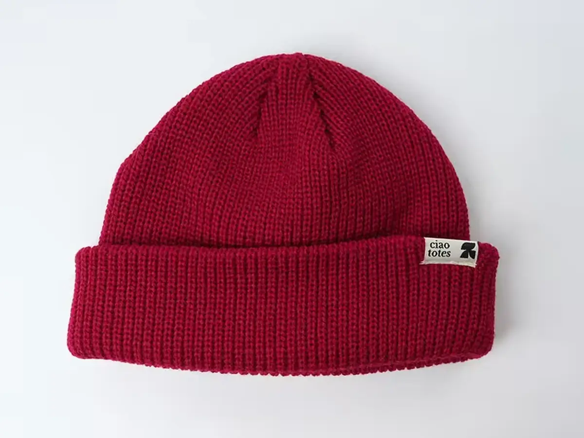 Red rib-knit beanie with a small front patch.