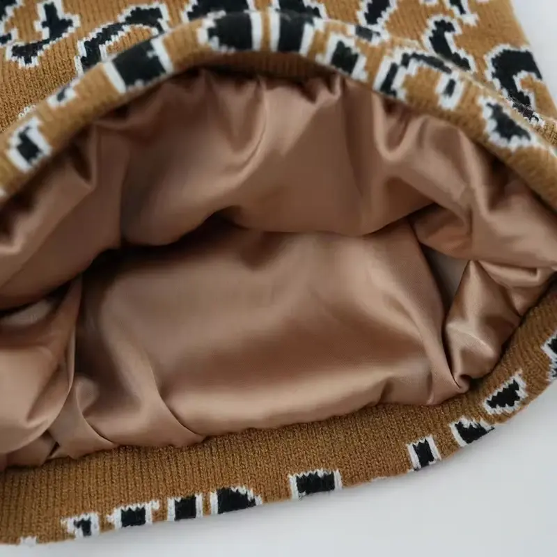 Smooth tan lining and its attachment inside a patterned knit beanie