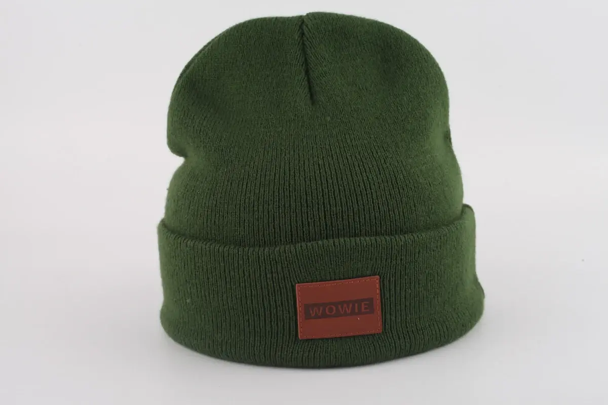 Green rib-knit beanie with a folded cuff and front patch