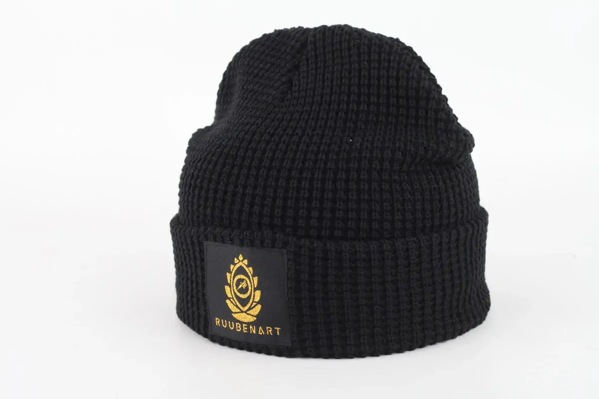 Black chunky rib-knit beanie with a folded cuff and front patch