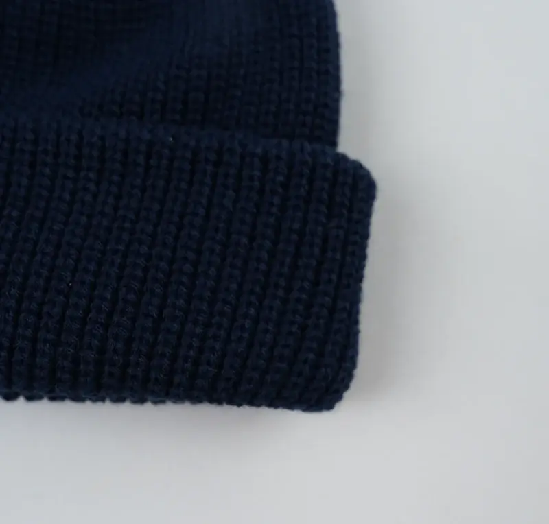 Close view of a navy knit surface and ribbed edge
