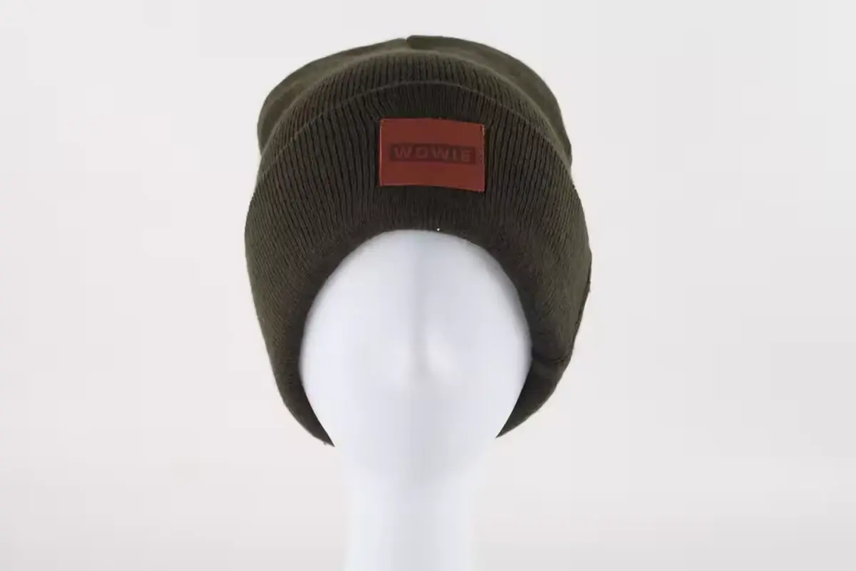 Dark knit beanie with a small rectangular patch on the folded cuff