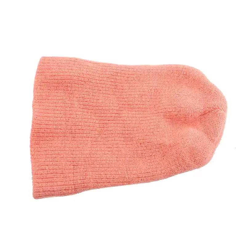 Peach knit beanie laid flat to show its long slouchy crown