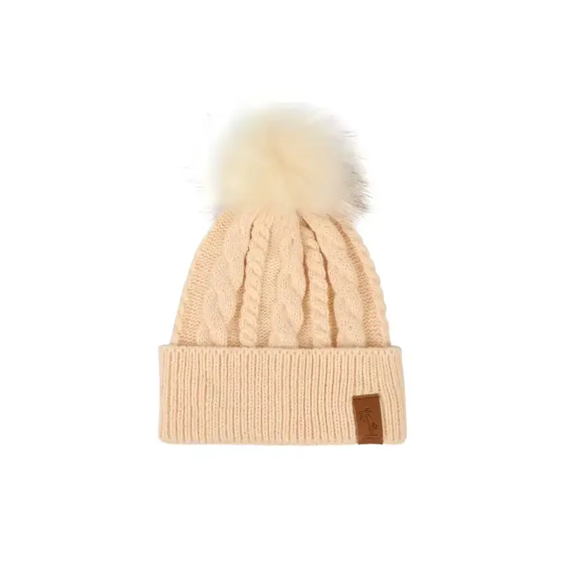 Cream cable-knit beanie with a pale pom-pom and folded cuff
