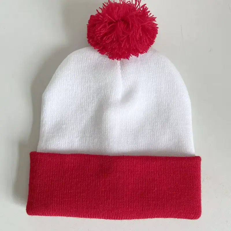White and red cuffed beanie with a red yarn pom