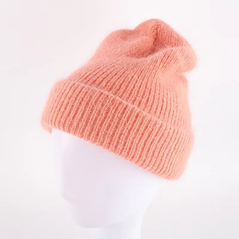 Peach pink slouchy knit beanie shown on a display head