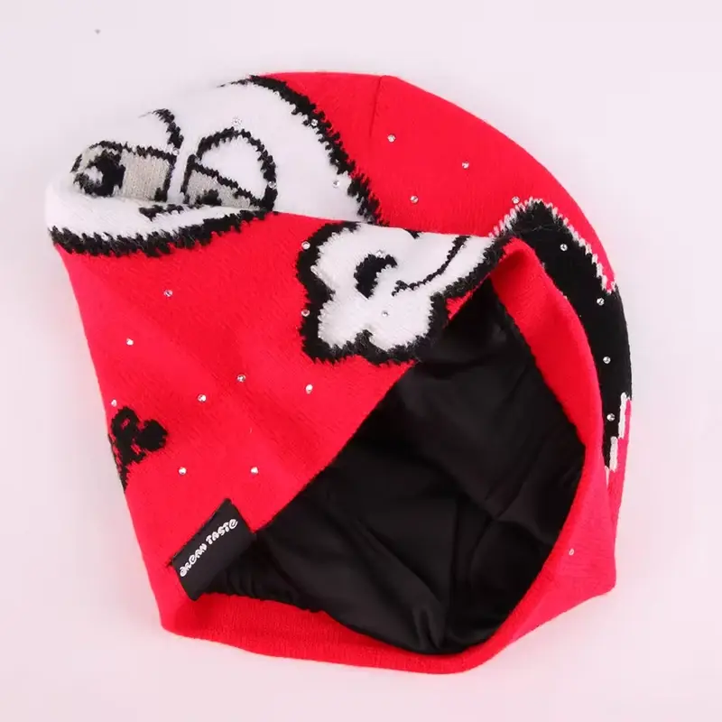 Red cuffless beanie turned to show its black inner layer and seam label