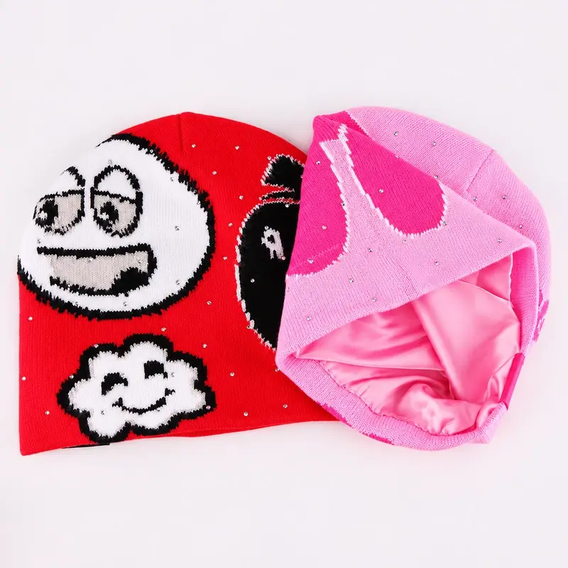 Folded red and pink cuffless beanies showing their inner layers and lower edges
