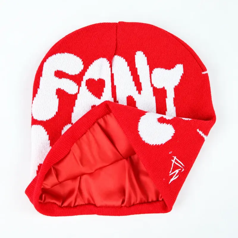 Red cuffless knit beanie with folded inner layer and white knit lettering