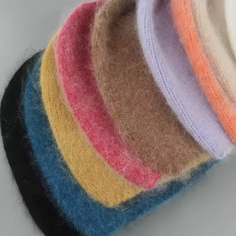 Close view of folded knit beanies in several colors showing layered fabric edges