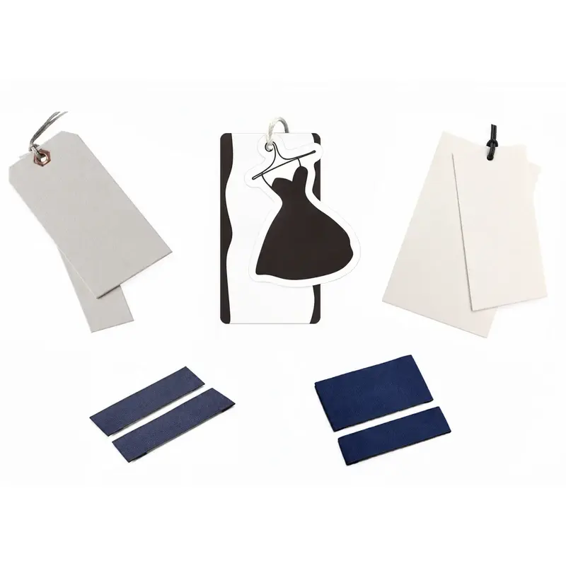 Blank paper hang tags and navy woven labels laid out on white