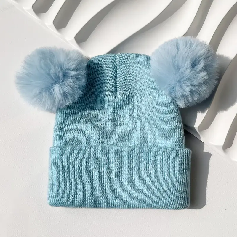 Blue double pom beanie with a wide folded cuff for logo placement