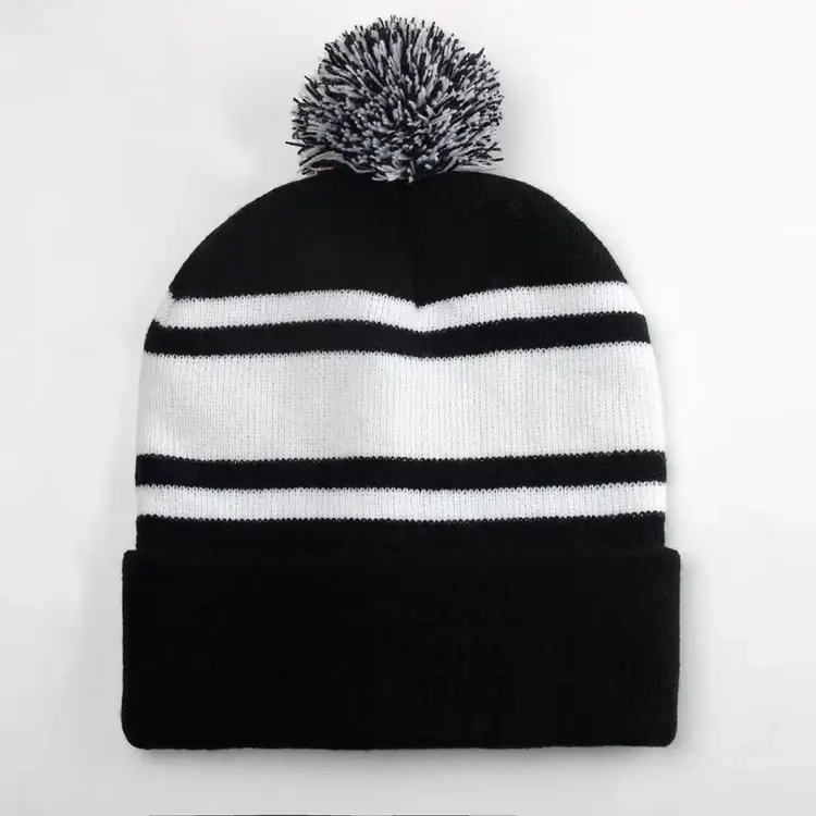 Black and white striped beanie with a yarn pom pom and folded cuff
