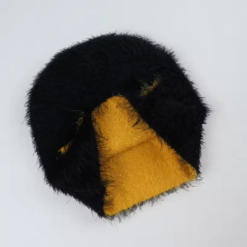 Inside view of a black winter beanie with warm yellow lining