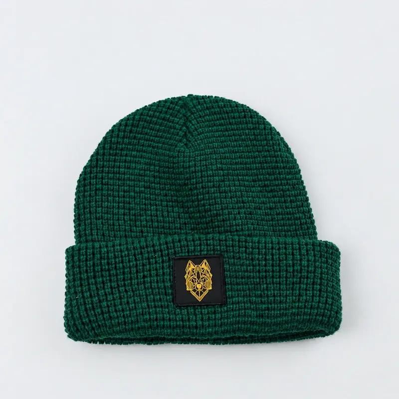 Dark green fisherman beanie with a gold embroidered cuff patch