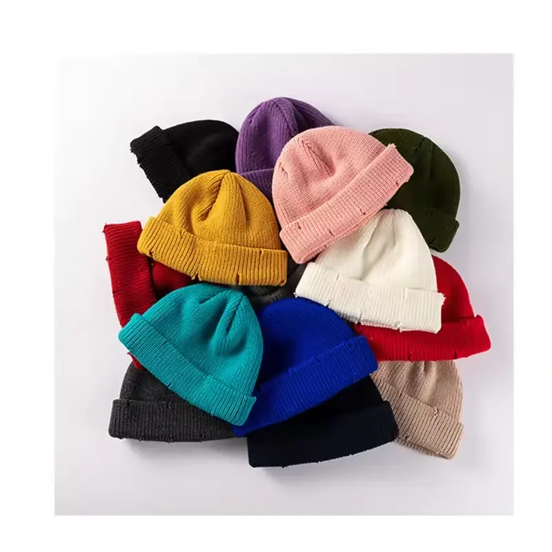About ten colorful knit beanies stacked together