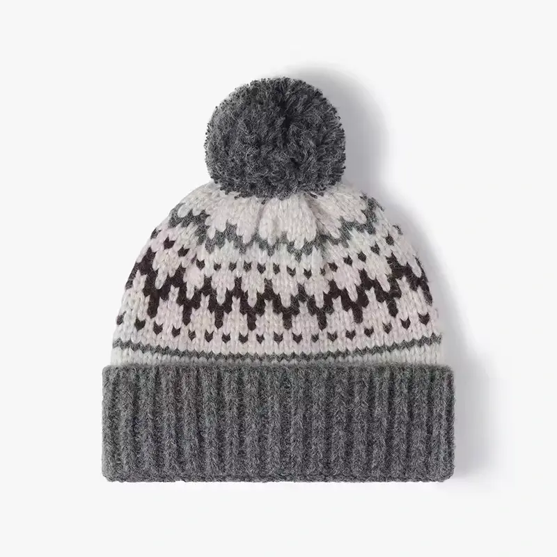Black-and-white geometric knit pattern with a gray pom-pom